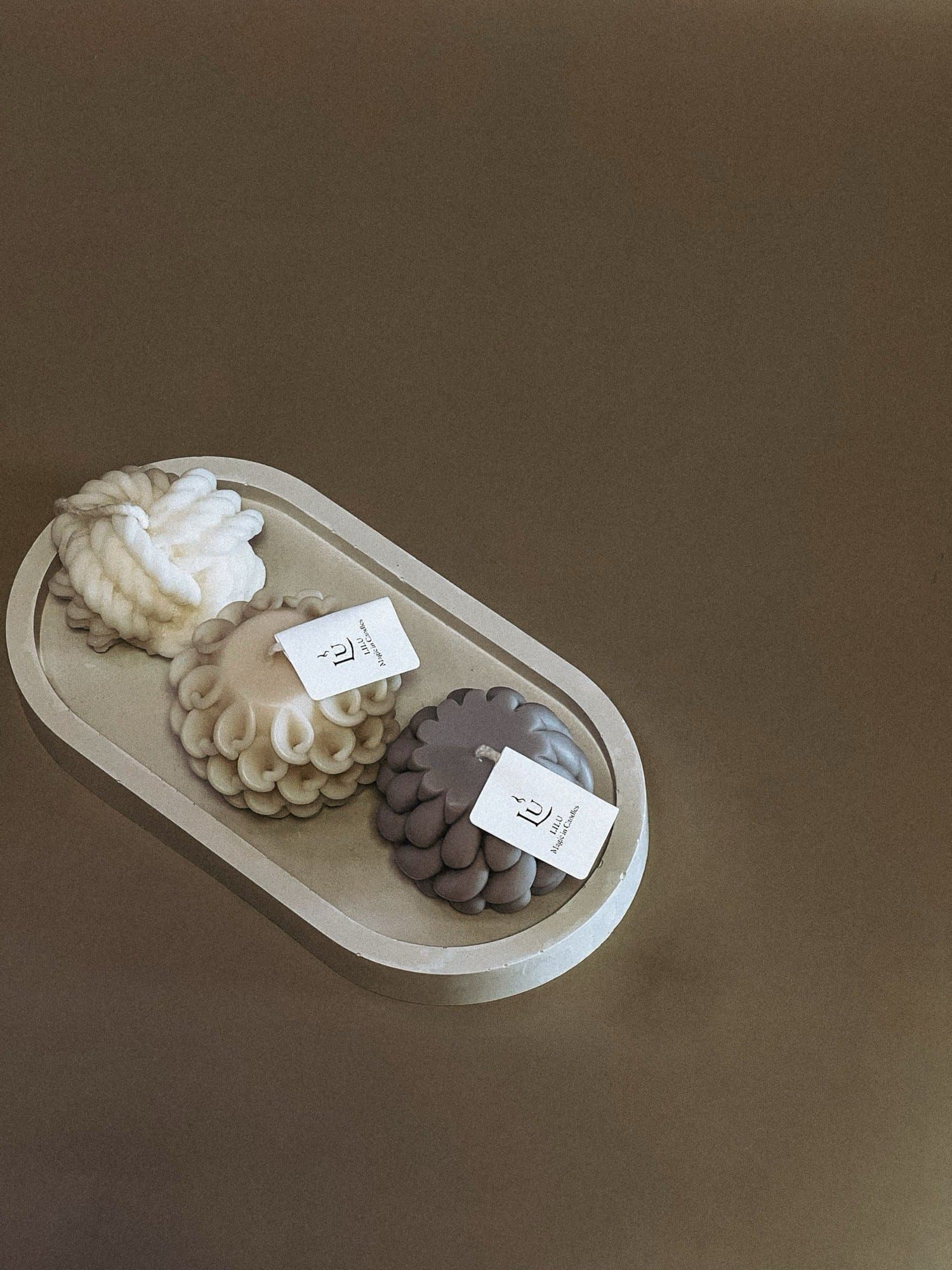 Sculpted candles resting on an oval Jesmonite tray